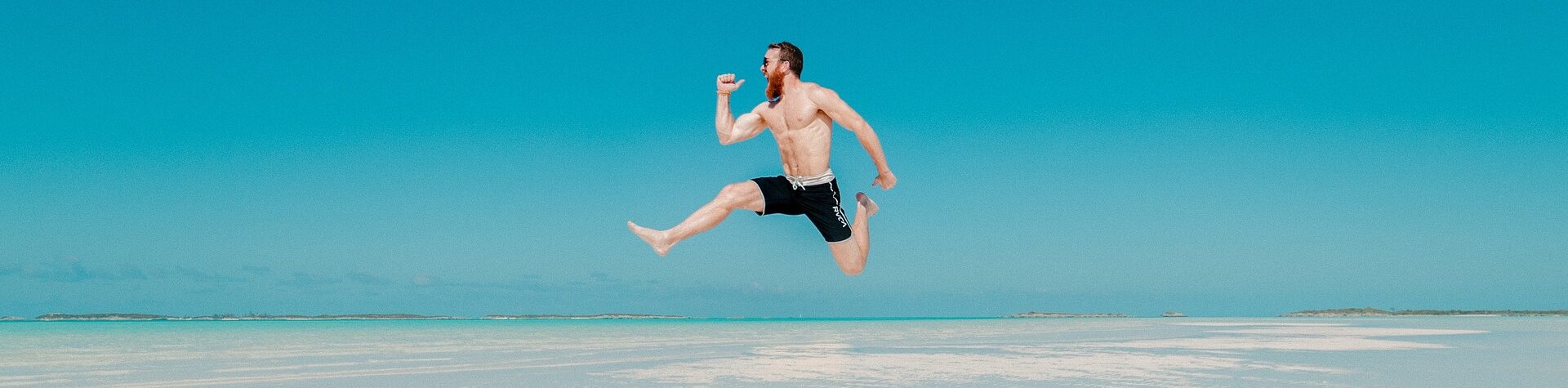 a man flying through the air while riding a wave in the ocean