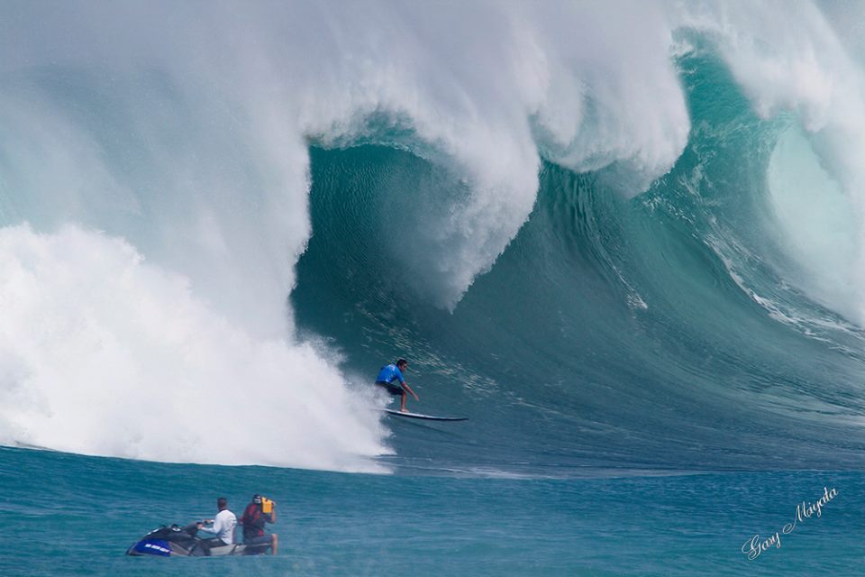 eddie4 a man riding a wave on a surfboard in the water