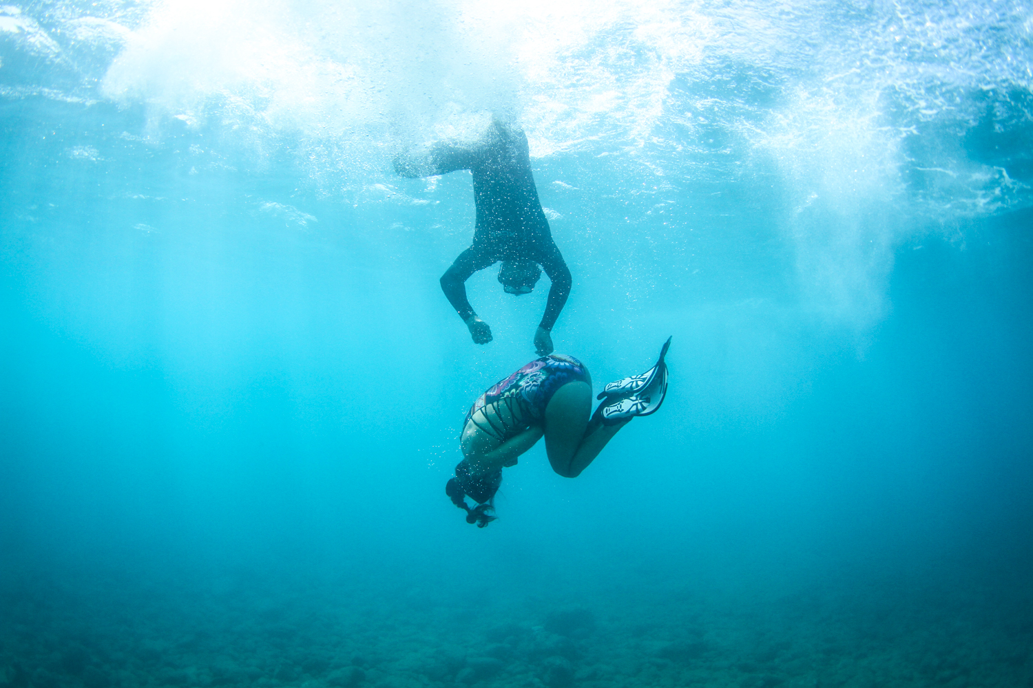 a man flying through the air while swimming in a body of water