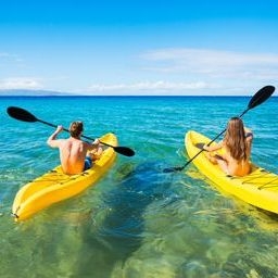 Kayaking in Oahu a person riding a surf board on a body of water