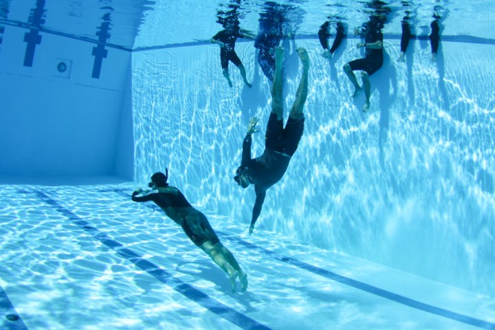 a group of people swimming in a pool of water