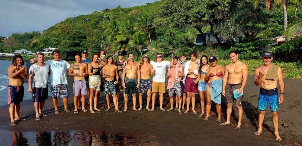 a group of people standing on a beach posing for the camera